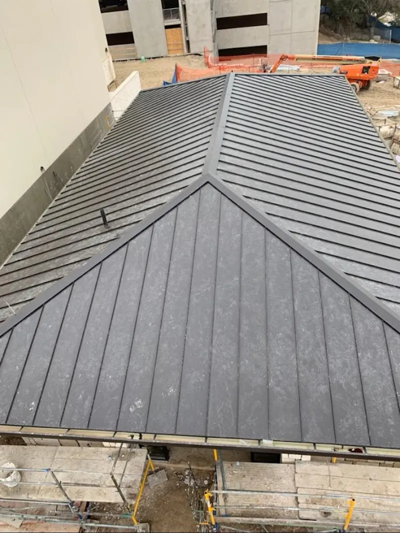 Commercial metal roof construction with crane equipment in Kent